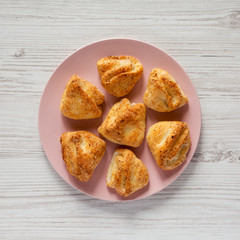 Top view, homemade cottage cheese biscuits on pink plate over white wooden background. Flat lay, overhead, from above.