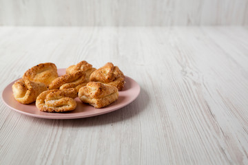 Home-baked cottage cheese biscuits on a pink plate, side view. Copy space.