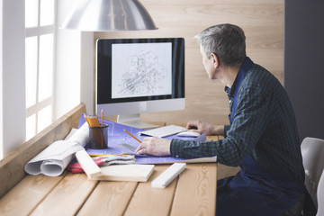 Engineer carpenter working on laptop and sketching project