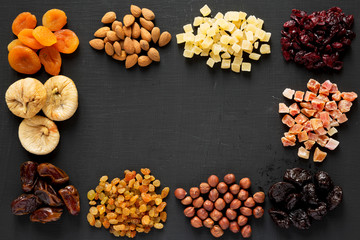 Frame of dried fruits and nuts on black background, top view. Overhead.