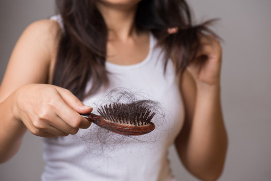 Healthy concept. Woman show her brush with long loss hair and looking at her hair.