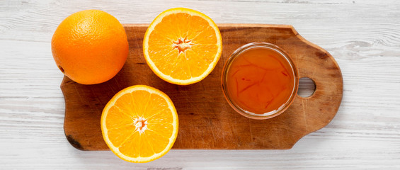 Homemade orange marmelade on rustic wooden board over white wooden surface, top view. Flat lay, overhead, from above.