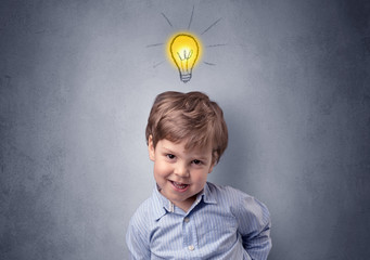 Adorable little kid mull over in front of a grey wall with idea symbol above his head