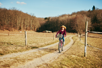 Obraz premium Cute little ten year old girl riding bicycle on countryside.