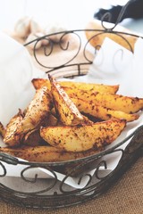 Baked potato wedges on basket - homemade snack made from vegetable. Healthy concept