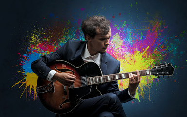 Young classical guitarist musician with colorful splotch wallpaper