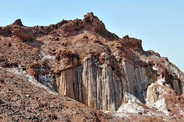 Textured colored minerals at the foot of the mountain.