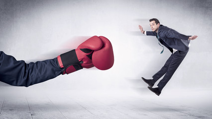 Huge Boxing Gloves punches innocent businessman concept
