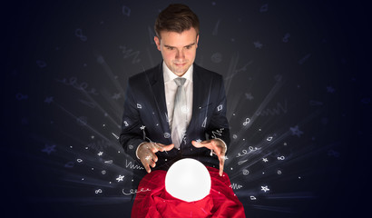 Gorgeous businessman looking to inspiration in a magic ball in his lap and doodle concept
