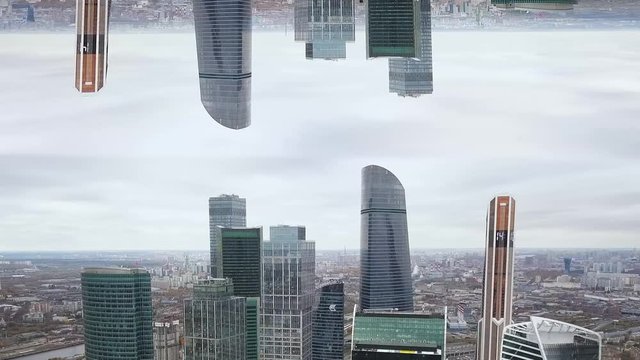 Aerial view of tall buildings and skyscrapers of a big city with mirror horizon effect. Beautiful skyscrapers with glass facade in New York, inception theme.
