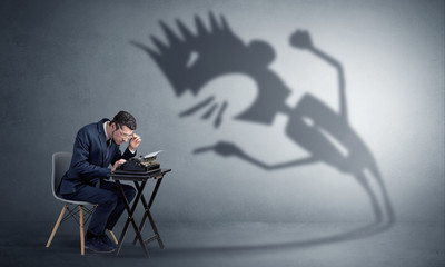 Man working hard and he is afraid of a yelling shadow
