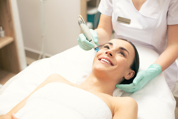 Close up of happy woman at the skin cleaning procedure