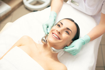 Excited woman smiling during the cryo-sticks massage