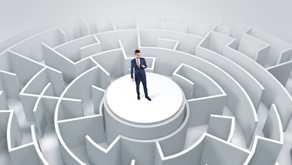 Businessman standing on the top a maze and looking through

