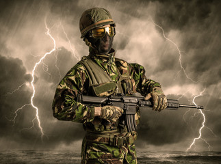 Armed soldier standing in rainy obscure weather
