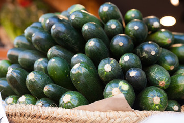 Fresh zucchini on market counter in wicker basket