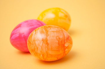 closeup of decorative painted easter eggs on yellow background
