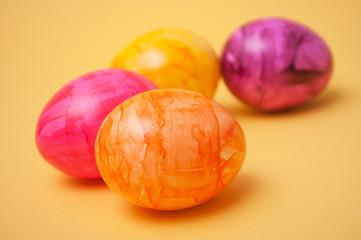 closeup of decorative painted easter eggs on yellow background