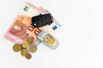 Obraz na płótnie Canvas coins, bills, a little car and a car key on white background 05