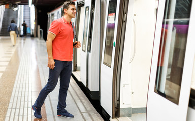 Man is standing on platform and running into train
