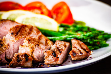 Grilled steak with asparagus on white background
