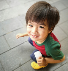 The boy is sitting in a public place.