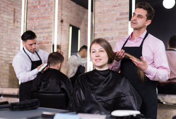 Man hairdresser discussing hairstyling with female client