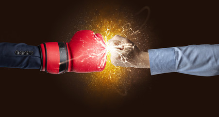 Two hands fighting with orange dust, spark, glow and smoke concept
