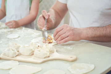 Uzbek national food manta, like dumplings, puts ingredients with a man's hand. selective control focus