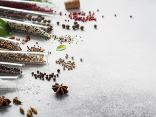 Various spices in glass test tubes and fresh herbs on gray background. Set of various spices and herbs flat lay. copy space