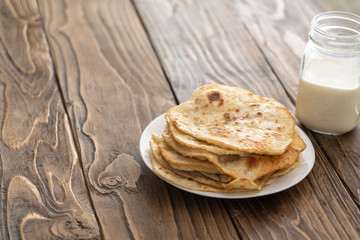 mug of milk and a plate of fried corn tortillas on a wooden textured Desk the view from the top. with free text, copy space,
