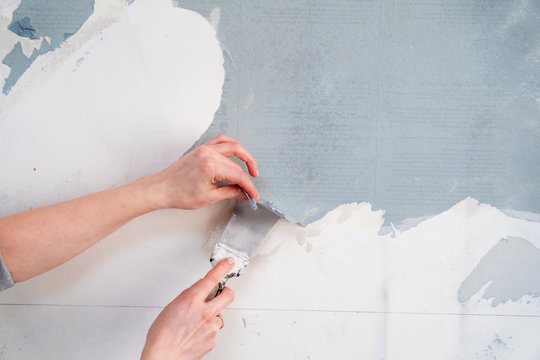 removing Wallpaper from the wall with a spatula. with free text space