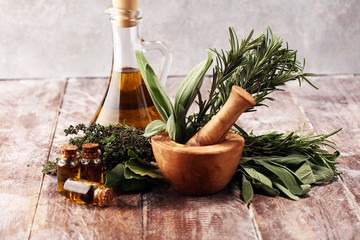 Fresh herbs from the garden and the different types of oils for massage and aromatherapy on table