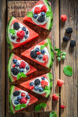 Tasty watermelon pizza with blueberries, raspberries and cream