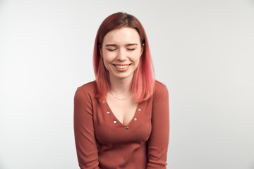 Excited adult girl closing her eyes with happiness rejoicing her success in life. Shining woman...