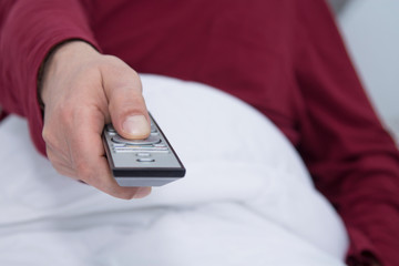 closeup adult man with tv remote control