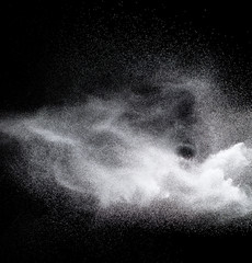 Fototapeta na wymiar White powder explosion.Freeze motion of white dust particles on black background.
