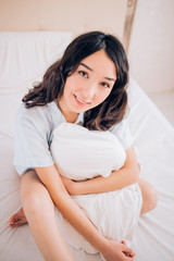 Beautiful Positive woman sitting in bed in morning