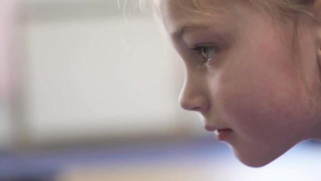 A close-up truly emotional demonstration of a professional child doing difficult gymnastics exercise (plank exercise).