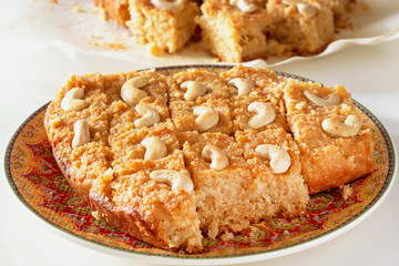 Basbousa or namoora traditional arabic semolina cake with cashew nuts and syrup. Selective focus.