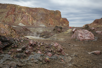 A landscape view across the Lahar and landslip area towards helicopters landed near the abandoned wharf on the active Volcano 