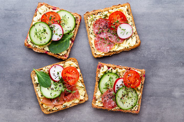 Sandwiches with cream cheese, vegetables and salami.