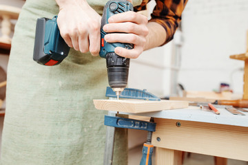 Worker man with screwdriver drill in carpentry. Handyman skills