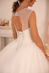 Fototapeta premium bride in a beautiful wedding dress on a white gentle background with flowers with patterns on embroidered lace