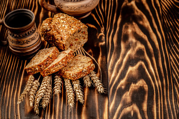 Fresh baked wholegrain rolls with seeds and ears of rye or wheat grain. top view. space for text