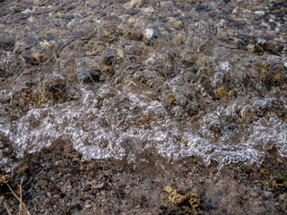 amazing seeshore, with a wave hitting the gravel beach