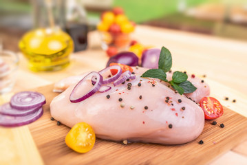 Raw chicken fillet and vegetables prepared for cooking on the kitchen.