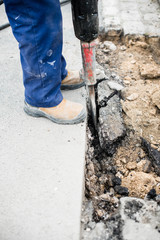 ouvrier remettant à niveau les pavés sur le bord de la route