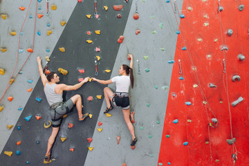 Obraz na płótnie Canvas Married couple having unusual date at rock wall.copy space