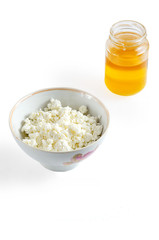 Cottage cheese in white bowl and honeyon white background